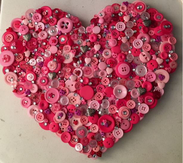 30 Creative DIY Button Crafts to Turn Spare Buttons Into Beautiful Decor A beautiful heart-shaped mosaic wall art piece intricately created from an assortment of pink, red, and magenta buttons accented with small crystals, highlighting DIY button crafts.