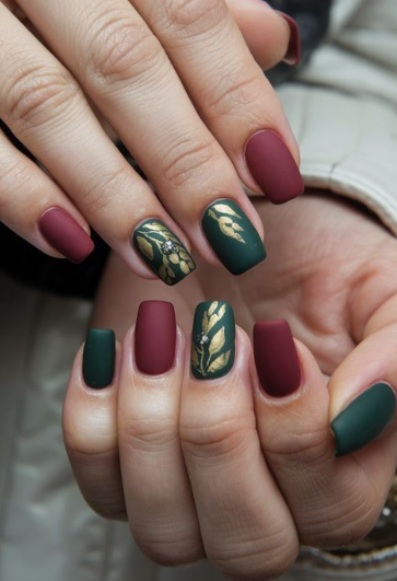  Festive square burgundy nail designs combined with matte dark green polish and metallic gold botanical leaf accent art.   