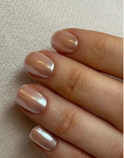 Short square nails with a neutral beige base and a pearlescent glazed chrome finish.