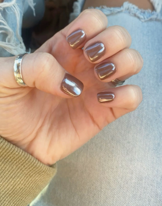 Short square brown chrome nails with a glossy, reflective mirror finish, paired with a silver ring.