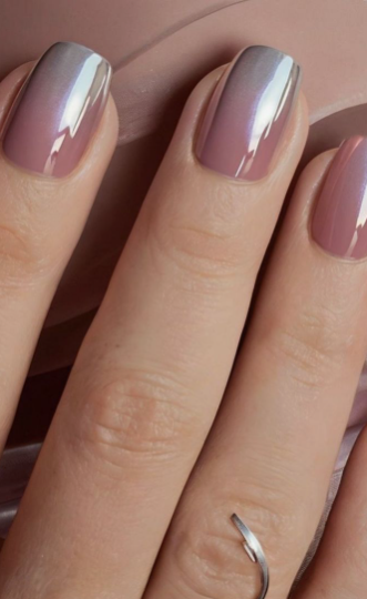 Short square mauve-pink ombre nails with a metallic chrome finish, accented by a silver ring.