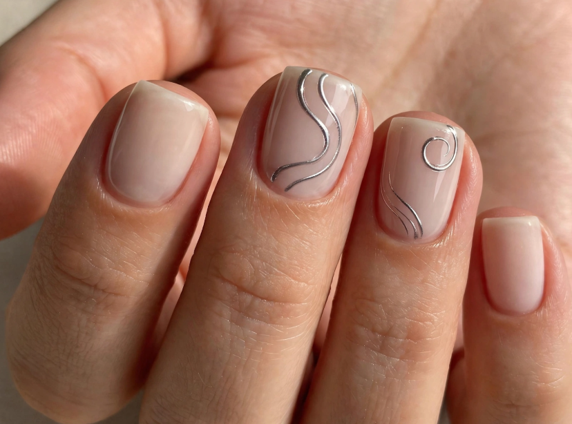 Short square neutral nude nails featuring delicate metallic silver chrome swirl and spiral line art accents.