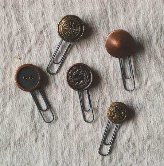 30 Creative DIY Button Crafts to Turn Spare Buttons Into Beautiful Decor A collection of handmade paperclips adorned with assorted vintage metal and patterned buttons, highlighting DIY button crafts.
