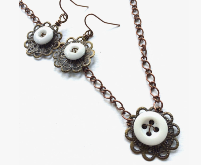 30 Creative DIY Button Crafts to Turn Spare Buttons Into Beautiful Decor A matching jewelry set featuring a necklace and drop earrings crafted from white buttons set within ornate bronze filigree findings and copper chain links, showcasing DIY button crafts.
