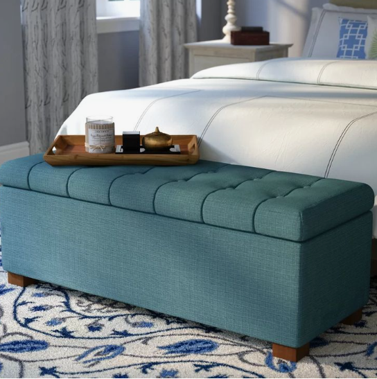 Small bedroom idea with no closet featuring a teal tufted storage bench at the foot of the bed topped with a wooden serving tray and decorative items.