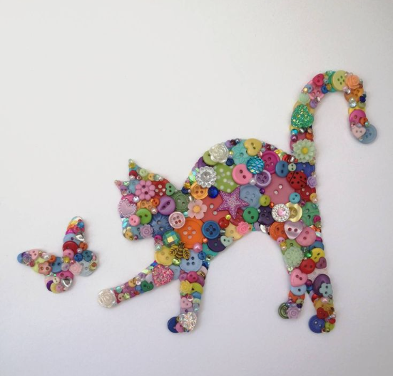 30 Creative DIY Button Crafts to Turn Spare Buttons Into Beautiful Decor A whimsical wall art piece featuring a stretching cat mosaic crafted entirely from a vibrant assortment of colorful buttons, accompanied by a matching small button butterfly, highlighting DIY button crafts.