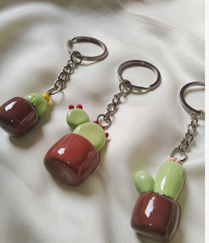 Three handmade cactus keychains in brown pots, highlighting cute air dry clay ideas for small accessories and crafts.