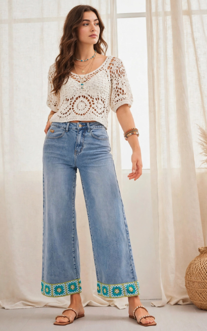 A woman wearing wide-leg jeans with custom turquoise and green crochet cuffs, paired with a matching crochet top, featured in 15 Crochet Upcycle Ideas.