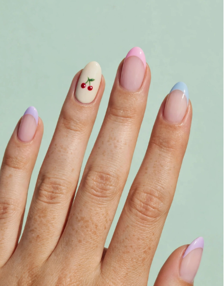 Pastel French tip nail art for beginners featuring colorful tips and a cute red cherry accent nail on oval nails.   