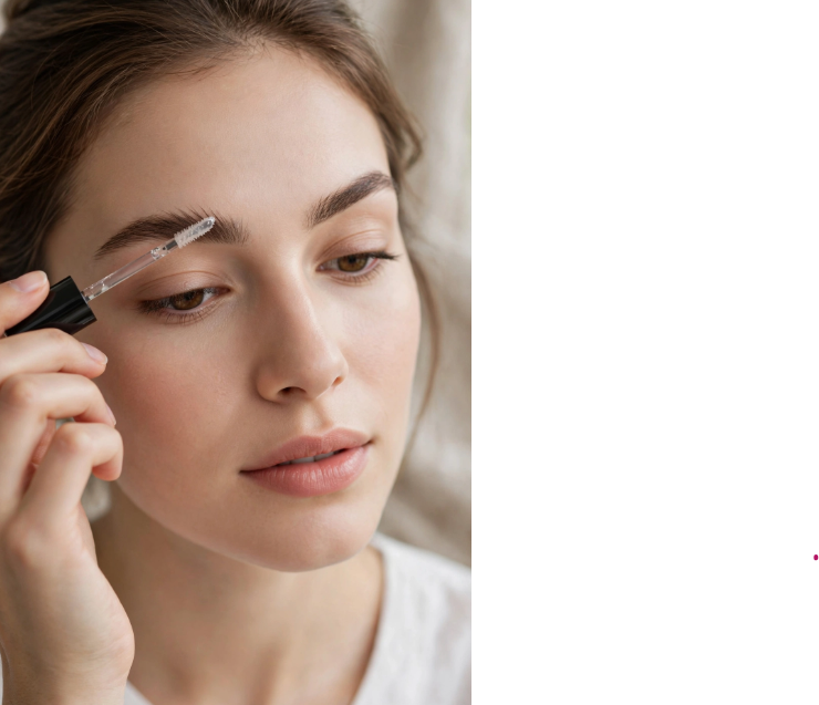 Woman shaping her eyebrows with clear brow gel spoolie as part of a minimal makeup routine with only 5 products.   