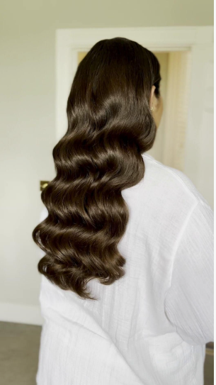 Back view of long, glossy dark brown hair styled in sleek Hollywood waves that showcase Fall 2026 Beauty Trends.