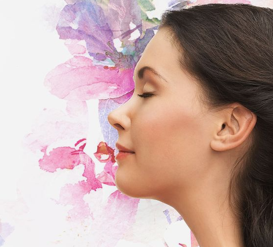 Profile view of a serene woman with her eyes closed against a soft watercolor floral background, highlighting Fall 2026 Beauty Trends.