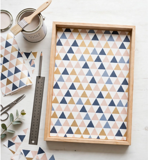  Wooden serving tray lined with geometric triangle patterned paper alongside paint, scissors, and a ruler, showing crafts you can finish in one afternoon.   