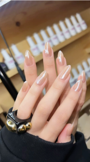 35 Short Nail Designs That Make Your Fingers Look Longer A close-up of short, almond-shaped nails finished with a glossy pearlescent sheen, serving as one of the short nail designs that make your fingers look longer.