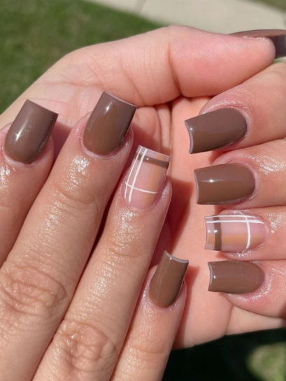 35 Short Nail Designs That Make Your Fingers Look Longer A close-up of short, square nails featuring a glossy brown polish accented with a chic brown, beige, and white plaid pattern, serving as one of the short nail designs that make your fingers look longer.