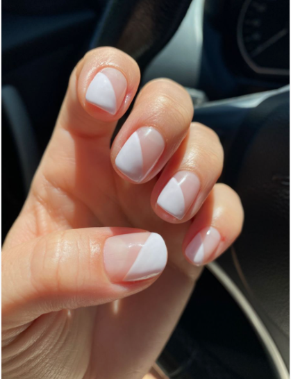 35 Short Nail Designs That Make Your Fingers Look Longer A close-up of short, square nails featuring a modern diagonal half-and-half white block design on a clear base, serving as one of the short nail designs that make your fingers look longer.