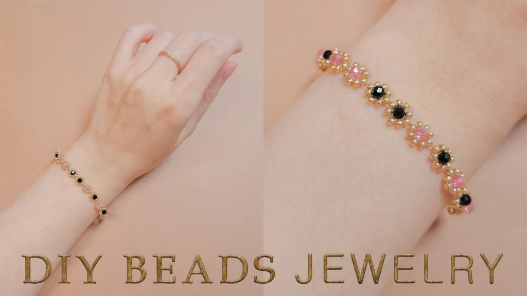 Hand wearing a delicate handmade floral beaded bracelet with pink and black crystals and gold seed beads, showcasing analog crafts to do instead of scrolling.   