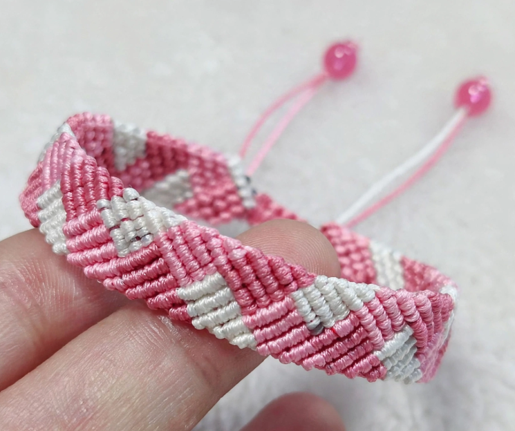 25 Craft Ideas for Teens That Are Actually Cool Handmade pink and white woven chevron friendship bracelet, representing easy craft ideas for teens.