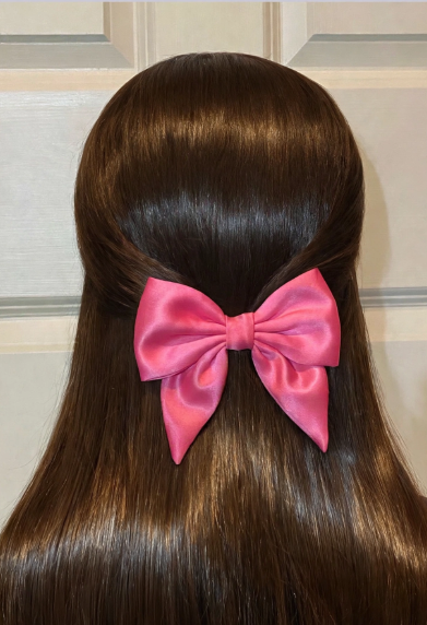 25 Craft Ideas for Teens That Are Actually Cool Handmade satin pink hair bow clipped onto a half-up brunette hairstyle, perfect for craft ideas for teens.