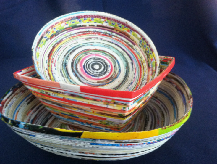 50+ Easy DIY Crafts to Sell and Make Extra Money Easy DIY crafts to sell: A nested set of handmade coiled paper bowls and trays crafted from glossy magazine strips, featuring intricate multicolored concentric rings and banded geometric designs.