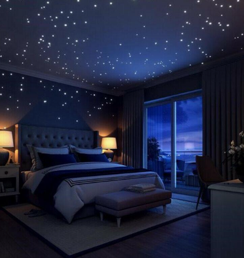 A dreamy bedroom featuring glowing star decals on the ceiling and dark walls, highlighting magical bedroom makeover ideas on a budget for a starry night effect.