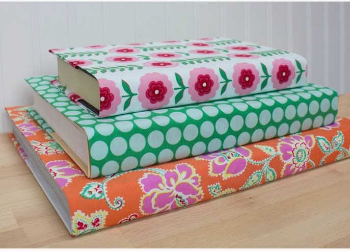 50+ Easy DIY Crafts to Sell and Make Extra Money Easy DIY crafts to sell: A stack of three hardcover books wrapped in custom colorful fabric covers, featuring a white floral pattern on top, a light blue polka dot on green in the middle, and an orange paisley print on the bottom.