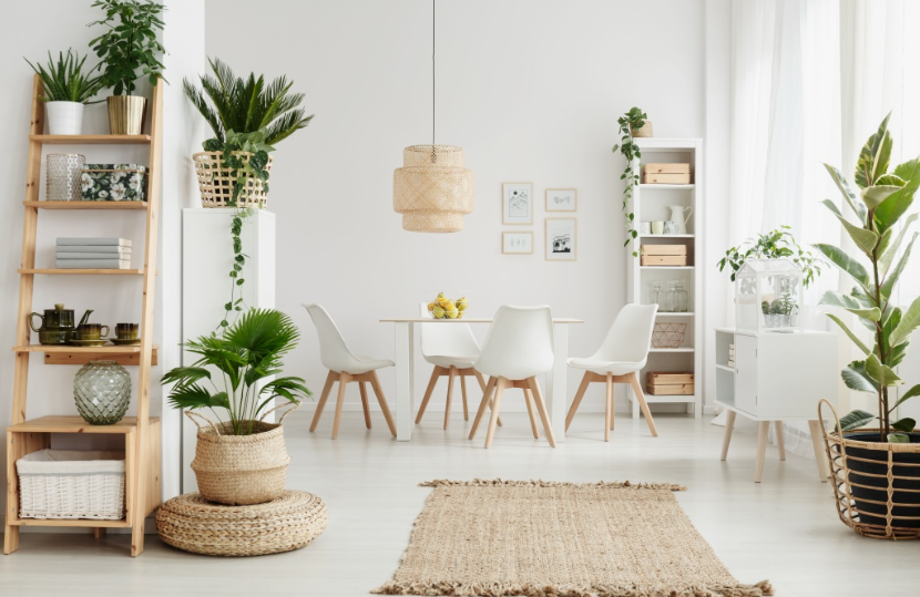 Small Living Room Decor Ideas on a Budget: 25 Stylish Ways to Make It Look Expensive Bright living room featuring small living room decor ideas on a budget with a wooden ladder shelf, abundant potted plants, a dining set with white chairs, a woven pendant light, and natural fiber rugs.