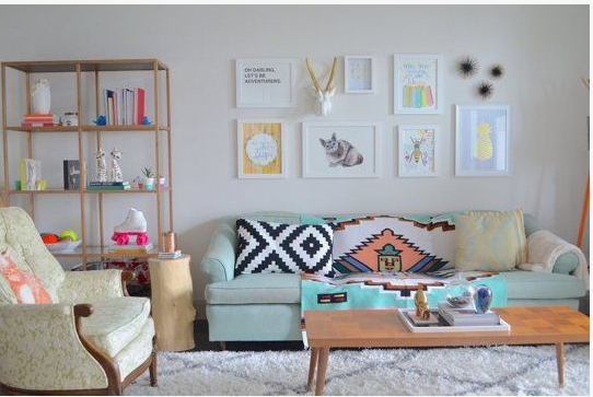 Small Living Room Decor Ideas on a Budget: 25 Stylish Ways to Make It Look Expensive Eclectic living room featuring small living room decor ideas on a budget with a light blue sofa, a patterned throw blanket, geometric accent pillows, a gallery wall of framed art, a wooden coffee table, an open shelving unit, and an armchair.