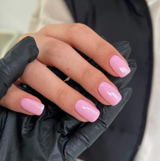 Short nail designs showcasing a glossy, soft pastel pink polish on neatly shaped square nails.