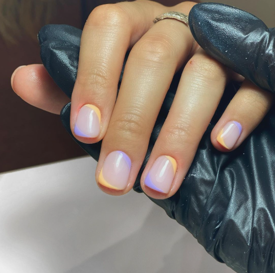 Short nail designs showcasing a vibrant double French tip in pastel orange and lavender on a neutral, glossy base.