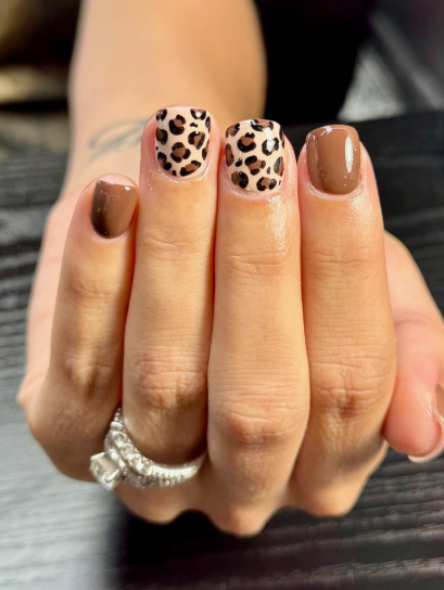 Short nail designs featuring glossy solid brown polish paired with chic animal print accent nails in shades of brown and black.