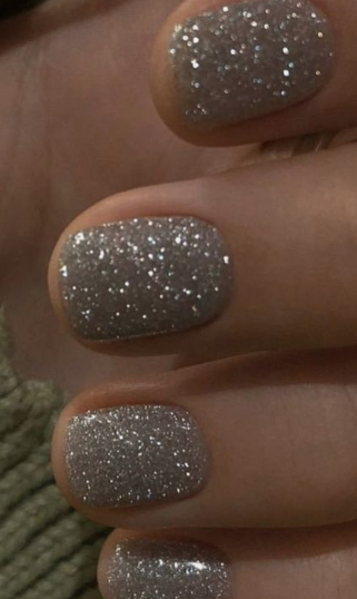 Short nail designs featuring sparkling reflective silver glitter polish on neat square nails.