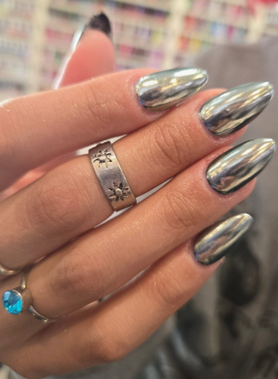 Short nail designs featuring a sleek, reflective silver chrome finish on elegantly shaped short almond nails.