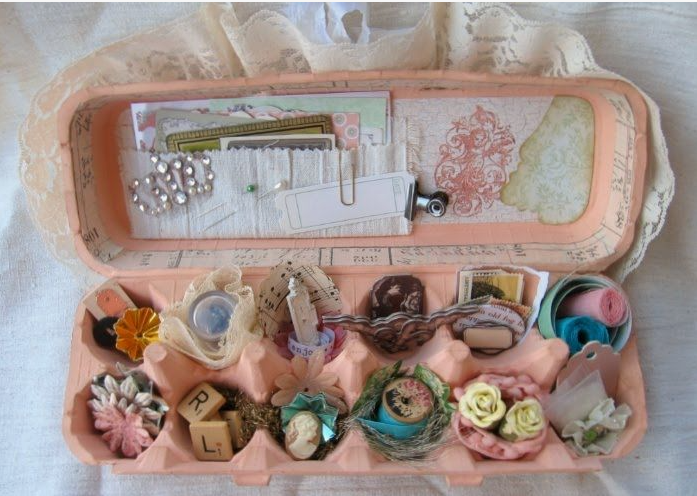 A painted cardboard egg carton transformed into a miniature craft supply organizer filled with buttons, lace, and tiny embellishments for DIY crafts using things you have at home.