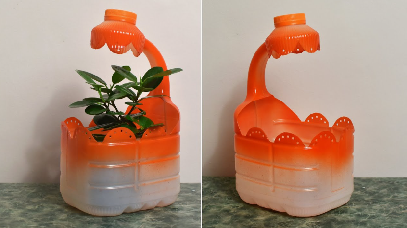 A plastic bottle cut and painted orange to look like a desk lamp planter holding a green plant, showcasing DIY crafts using things you have at home.