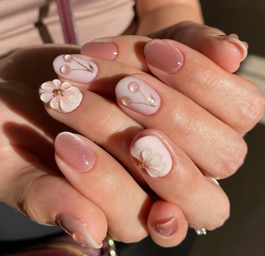15 Stunning 3D Nail Designs to Try This Season Chic 3D nail designs featuring delicate sculpted floral and cherry motifs over a soft pink base.