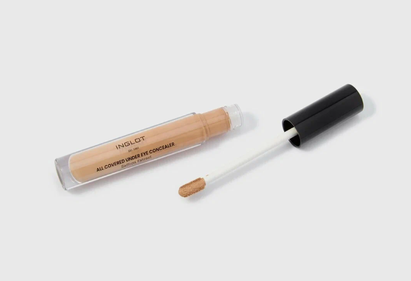The Minimal Makeup Guide: How to Look Polished With Less Makeup An open tube of Inglot All Covered Under Eye Concealer with its applicator wand resting beside it against a clean white background.
