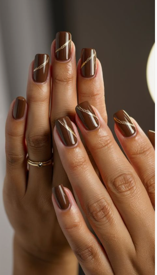 Glossy dark brown short square nails with delicate gold foil lines showcasing low-maintenance nail designs.