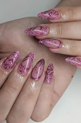 15 Stunning 3D Nail Designs to Try This Season Striking 3D nail designs featuring metallic pink sculpted heart patterns and glossy droplet details on a neutral almond-shaped manicure.