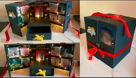 A DIY anniversary gift box decorated with red ribbons, fairy lights, and interior photo frames, shown both open and closed.