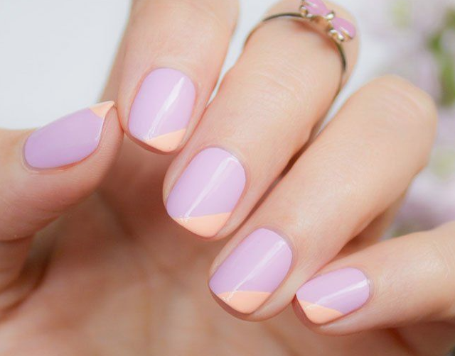 Short, polished nails showcasing a clean color-blocked design in pastel lavender and peach, representing easy nail designs for short nails.