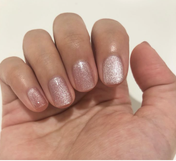 Short, rounded nails featuring a shimmering, metallic pink cat-eye polish finish that catches the light, exemplifying easy nail designs for short nails.
