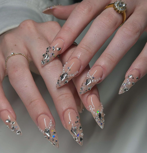 15 Stunning 3D Nail Designs to Try This Season Glamorous 3D nail designs featuring stunning rhinestone crystals, pearls, and gemstone French tips on a nude almond-shaped manicure.