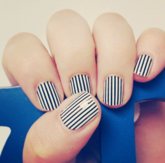 Short, well-maintained nails showcasing a bold black-and-white striped pattern, illustrating easy nail designs for short nails.