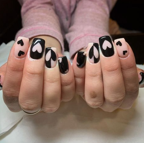 Short, neatly-rounded nails featuring a chic half-moon manicure with deep dark burgundy polish and bare, semi-circle cutouts at the base, serving as a stylish example of easy nail designs for short nails.