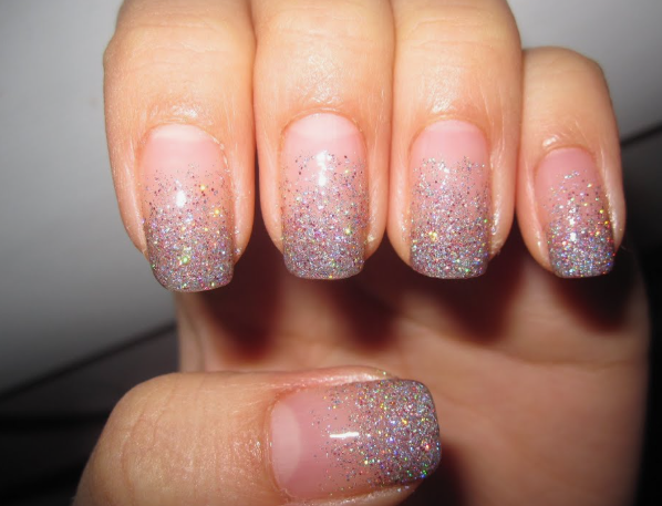Short, neatly trimmed nails featuring a clean nude base with a dazzling silver glitter gradient fading from the tips, offering a sparkling and simple option for easy nail designs for short nails.