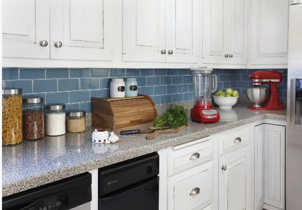 A kitchen featuring white cabinets, blue subway tile backsplash, granite countertops, and countertop appliances including a red blender and stand mixer, showcasing functional inspiration for renter-friendly home decor ideas.