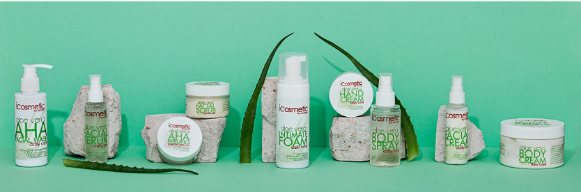 An organized collection of green-and-white cosmetic products, including aloe vera facial wash, serums, creams, and sprays displayed on stone blocks against a vibrant turquoise background with fresh aloe leaves, offering helpful guidance for a simple skincare routine for beginners.