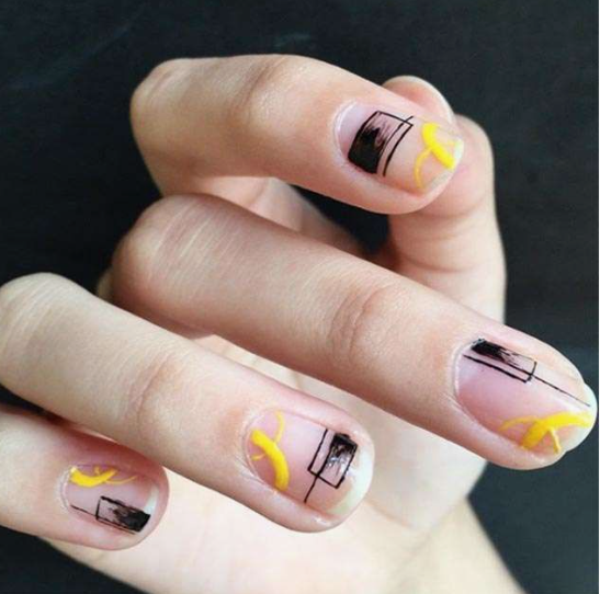 Short, rounded nails with a glossy nude base featuring geometric black line art, black blocks, and vibrant yellow curved accents, serving as a creative inspiration for nail designs for short nail beds.