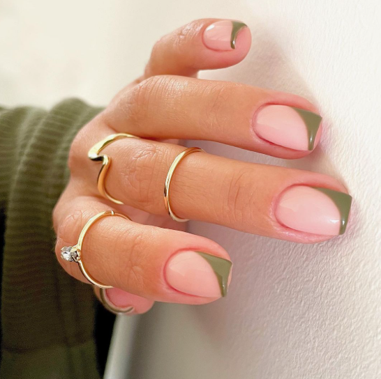 Short, squared nails featuring a glossy nude base and modern geometric olive green tips, making it a trendy choice for nail designs for short nail beds.